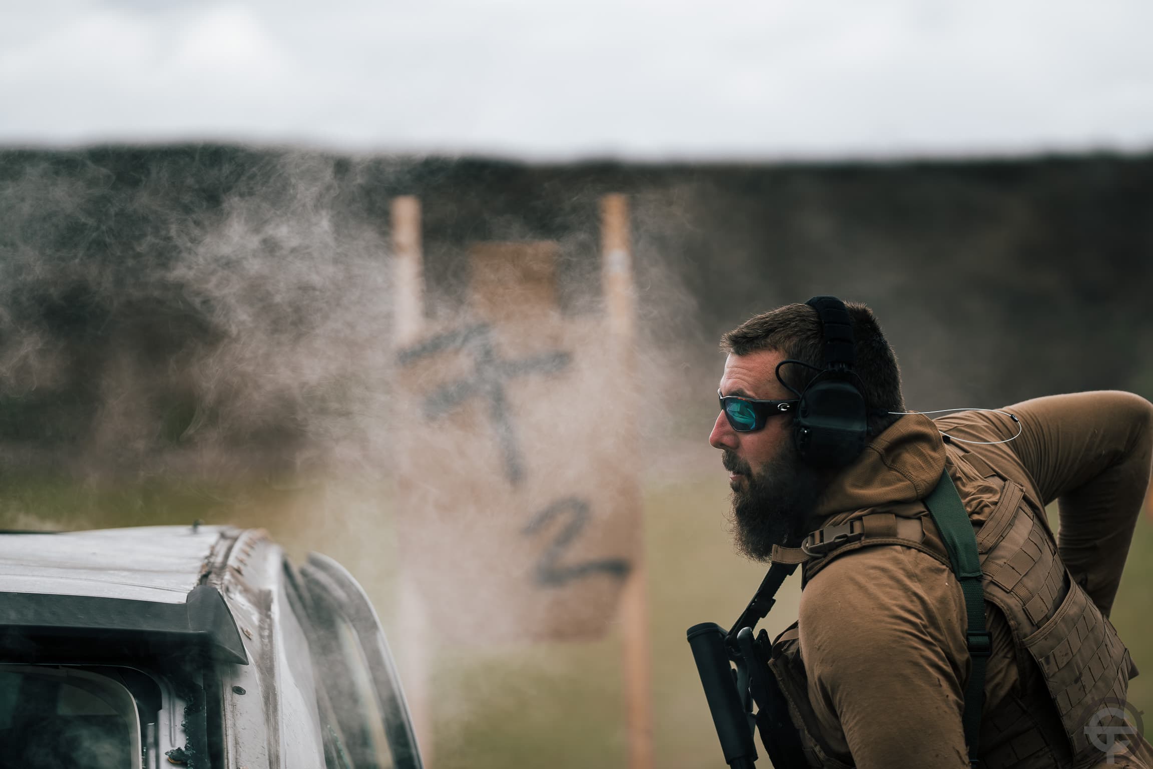 Tactical operator with smoke drifting past during vehicle drill