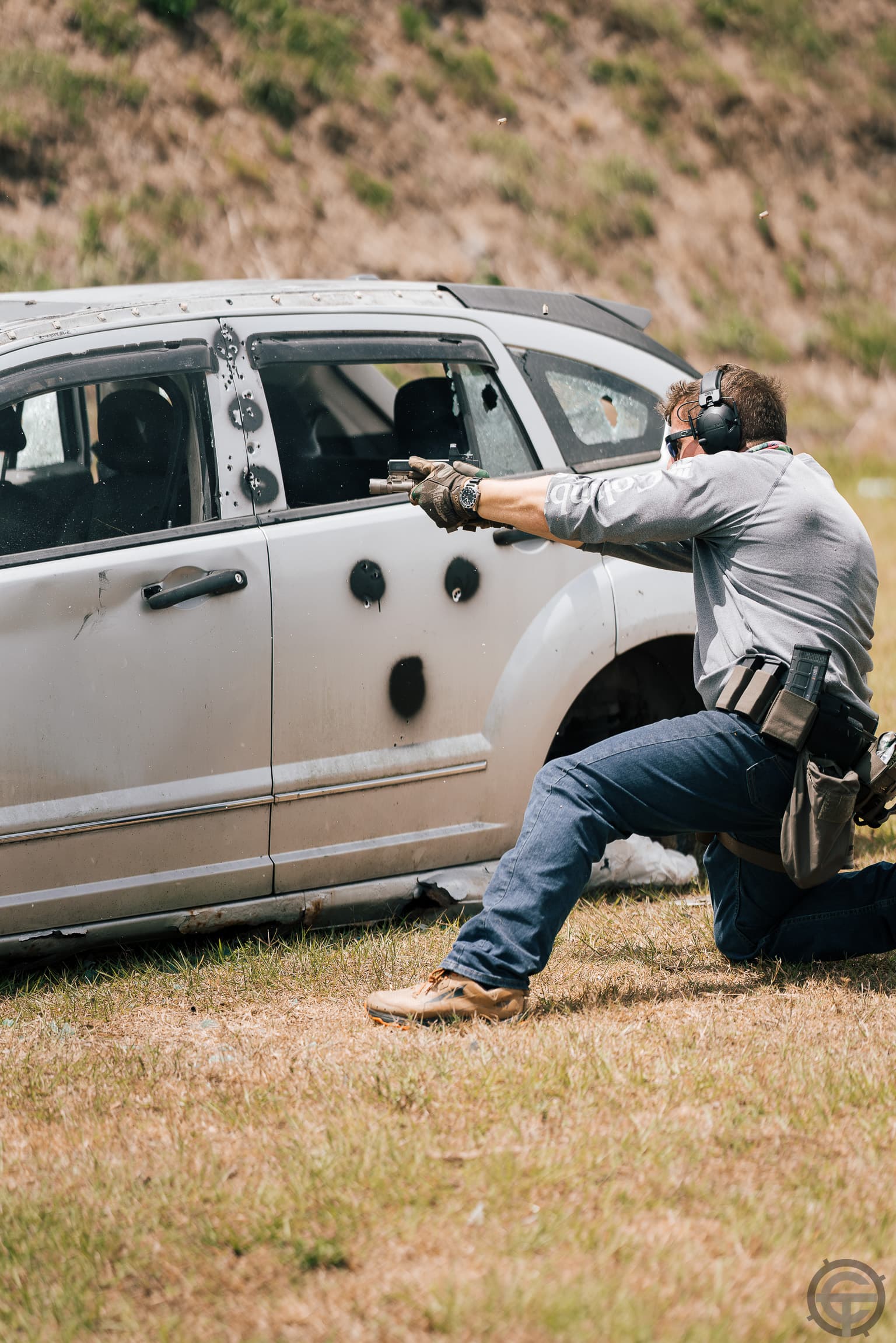 Defensive shooting from kneeling position behind vehicle during tactics training